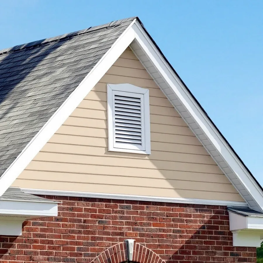 Upper gable of a brick house finished in beige lap siding under a shingle roof