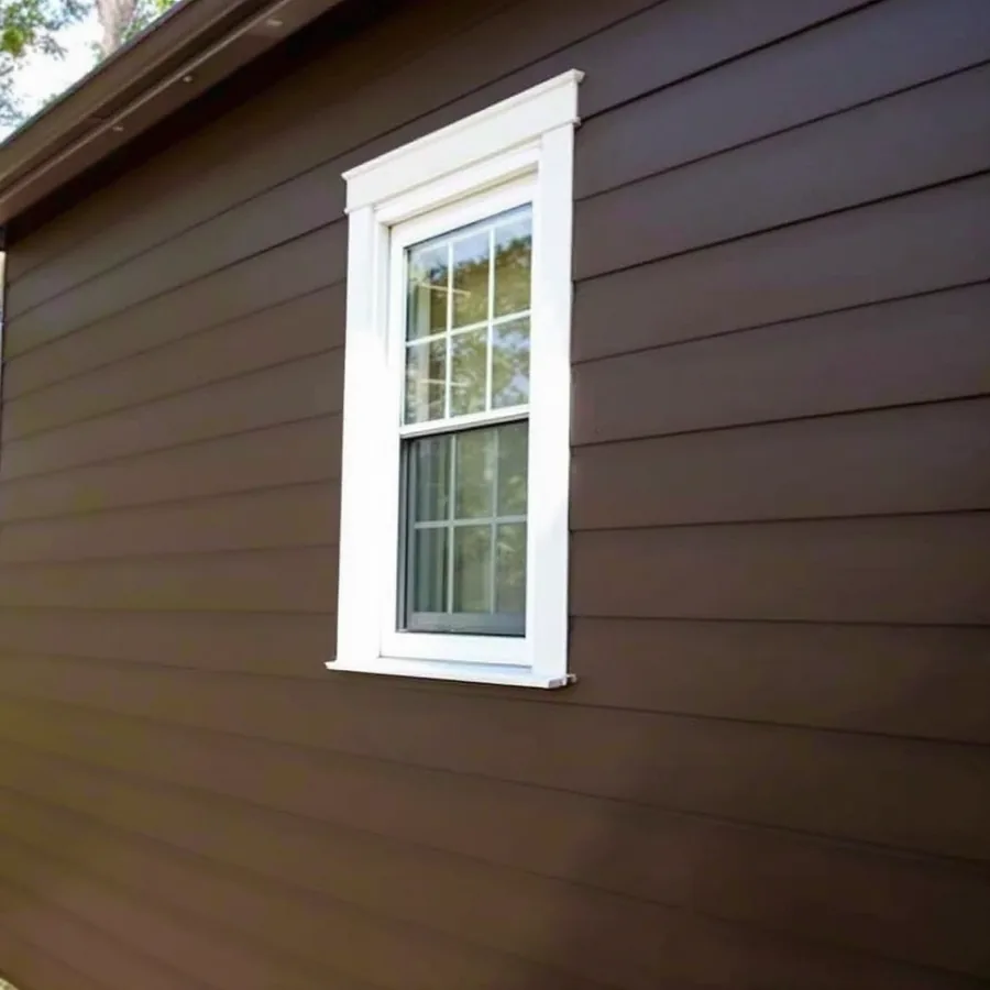 Dark bronze steel lap siding panels with a low sheen on the side wall of a house