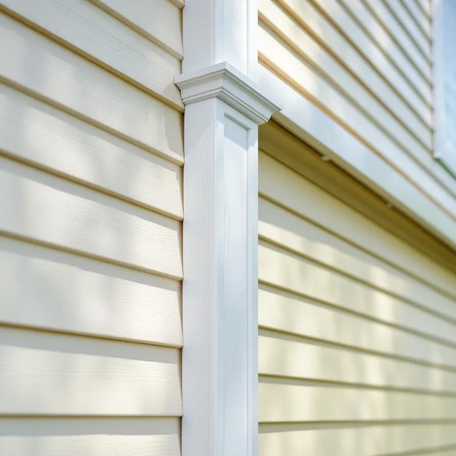 Cream lap siding on two walls sliding into a wide white corner post