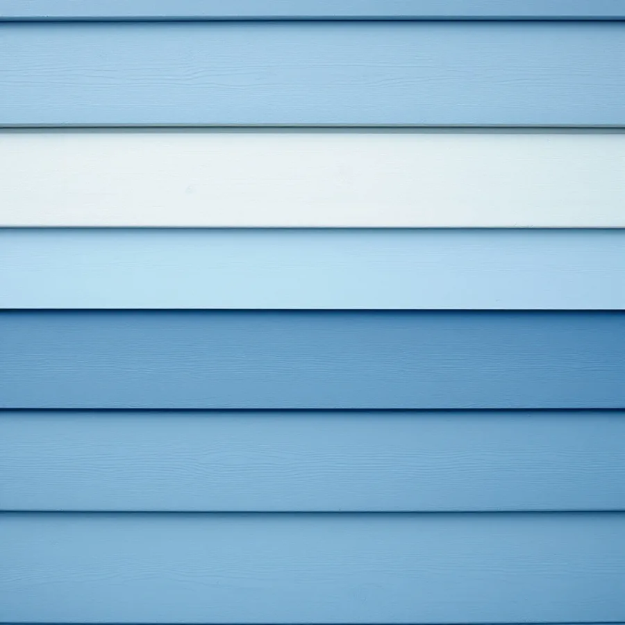 Wall of blue lap siding in which two courses are a visibly paler shade than the rest